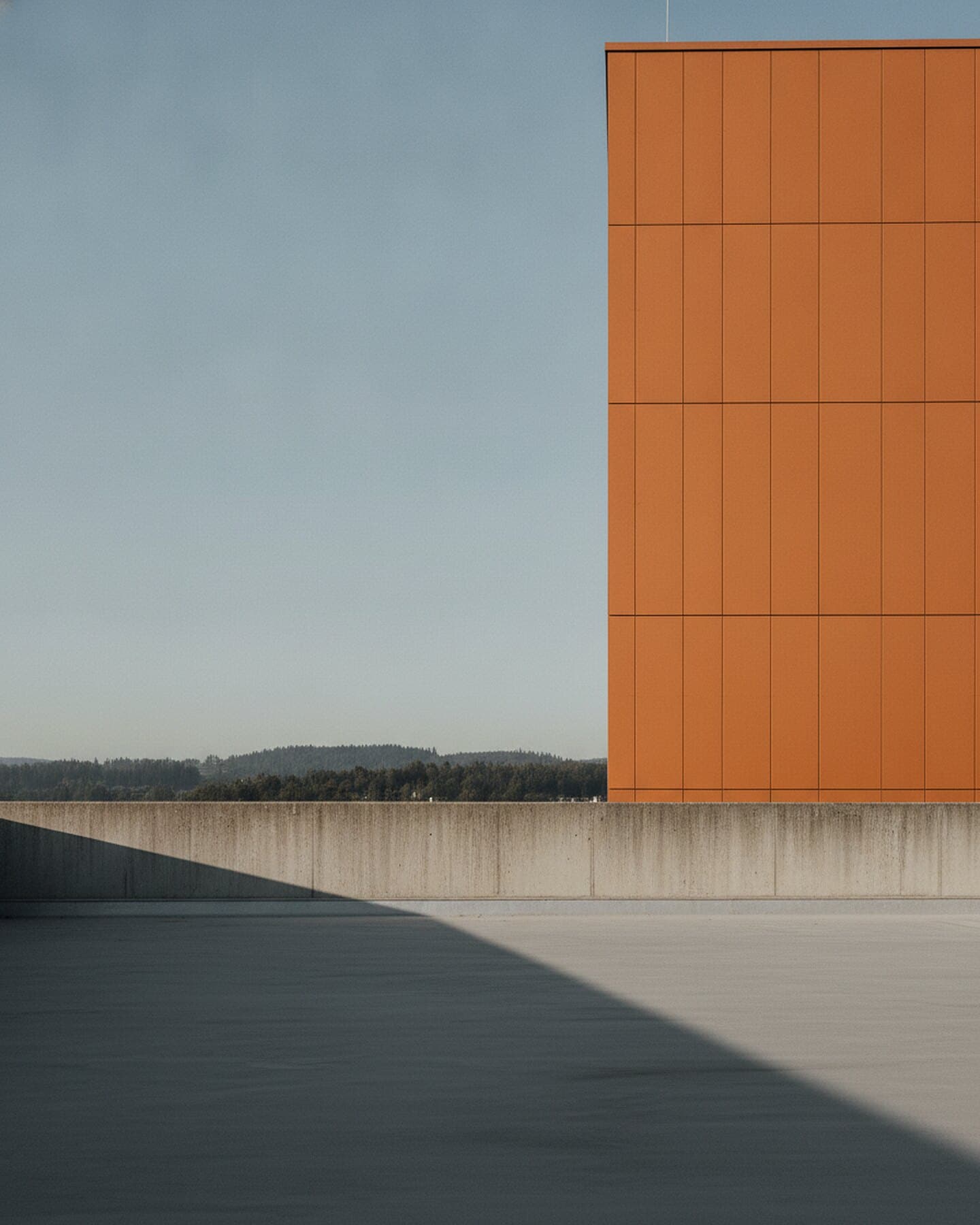 Flachdach eines neu erstellten Wohnbaus mit oranger Fassade im Schweizer Mittelland