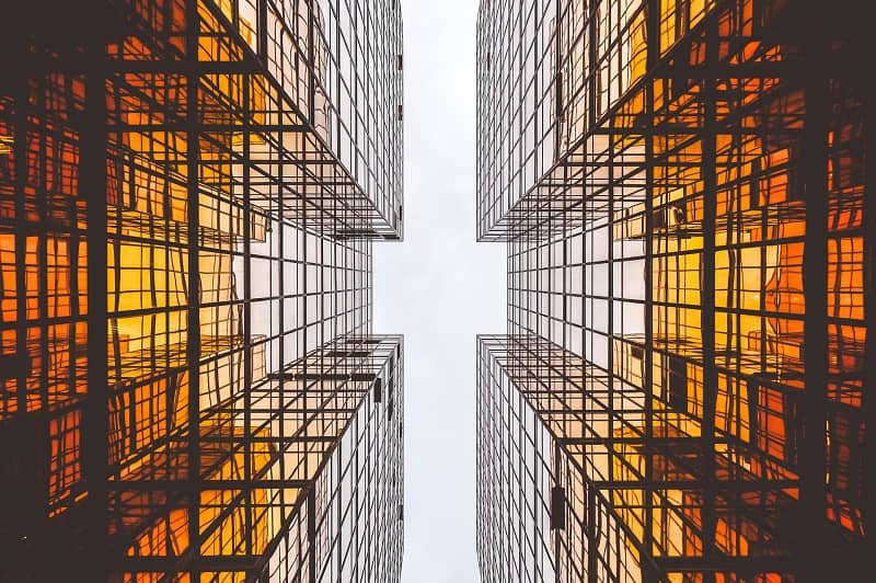 Blick zwischen zwei Glasfassaden mit orangen Reflexen